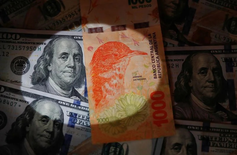 Foto de archivo de un billete de 1.000 pesos argentinos sobre varios billetes de dólar estadounidense a modo ilustrativo. Foto tomada el 17 de octubre de 2022. REUTERS/Agustin Marcarian/