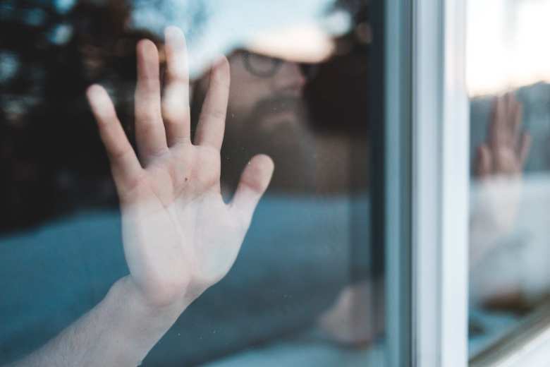 Hombre detrás de una ventana